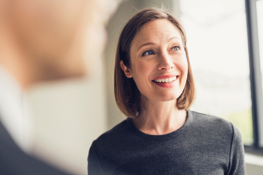 gettyimages-656228197-900x600 A woman in a black shirt smiling and listening